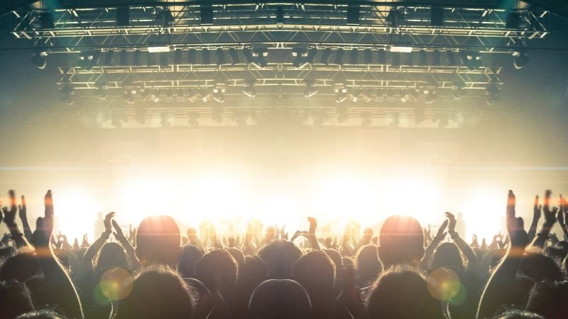 Várias pessoas dentro de um estabelecimento onde decorre um concerto